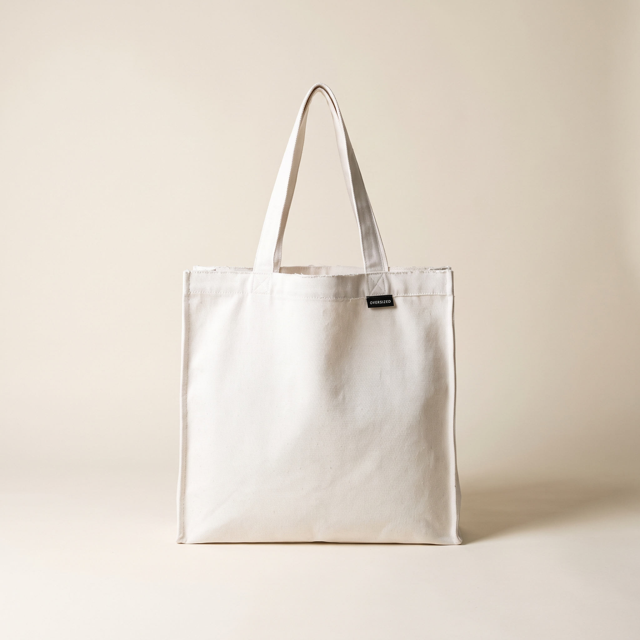 Raw Edge Tote in white canvas with OVERSIZED wordmark tag